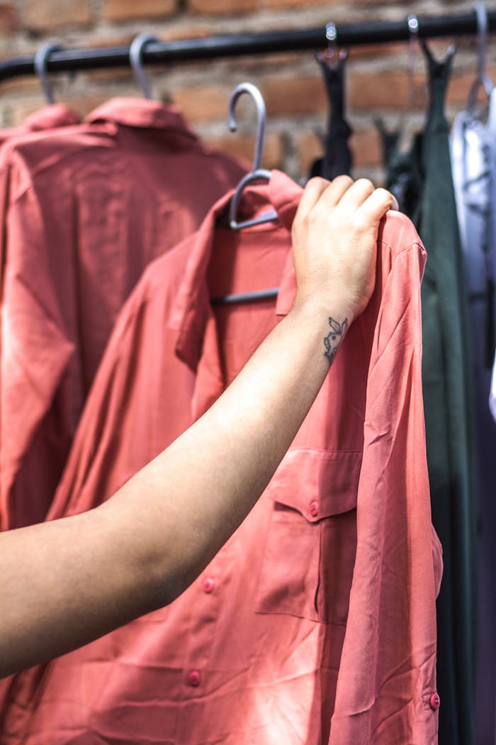 Person Holding Red Dress Shirt on Hanger